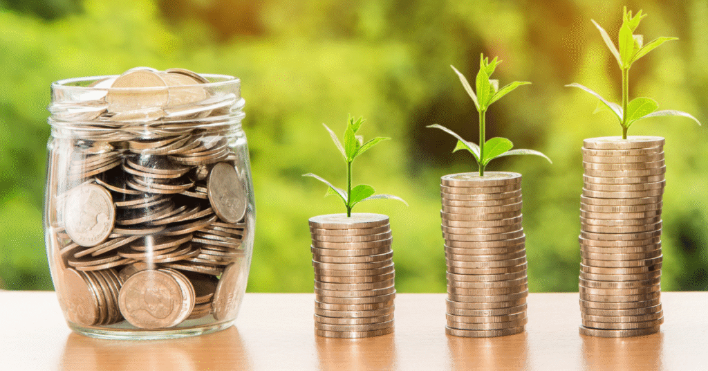 Three stacks of coins with small green plants growing from them, representing financial growth and stability after divorce.