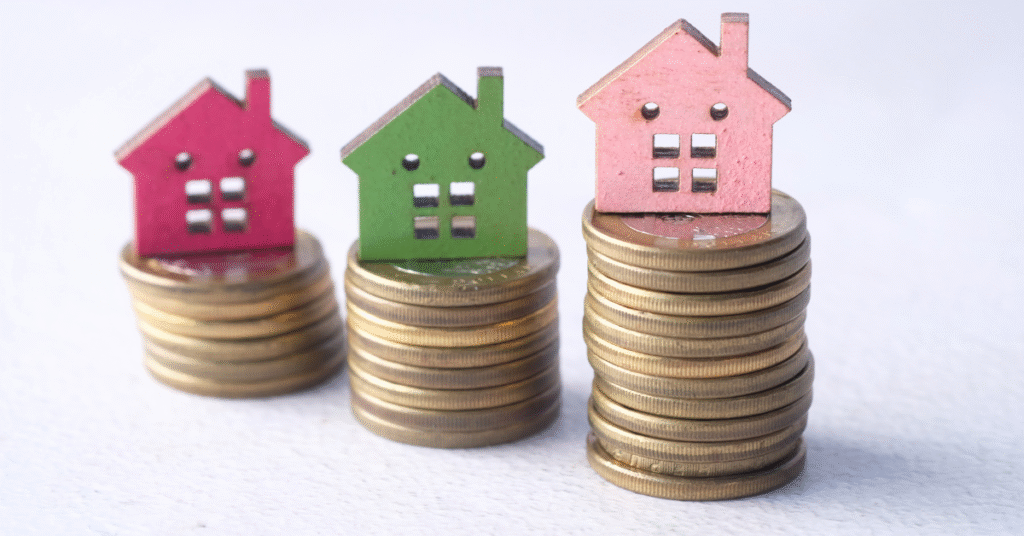 Small colourful house icons placed on stacked coins, illustrating rising costs and the difference between mediation and solicitor-led divorce in the UK.